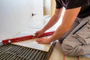 Vinyl planks beside a damp mop and a small spill being wiped from a kitchen floor.